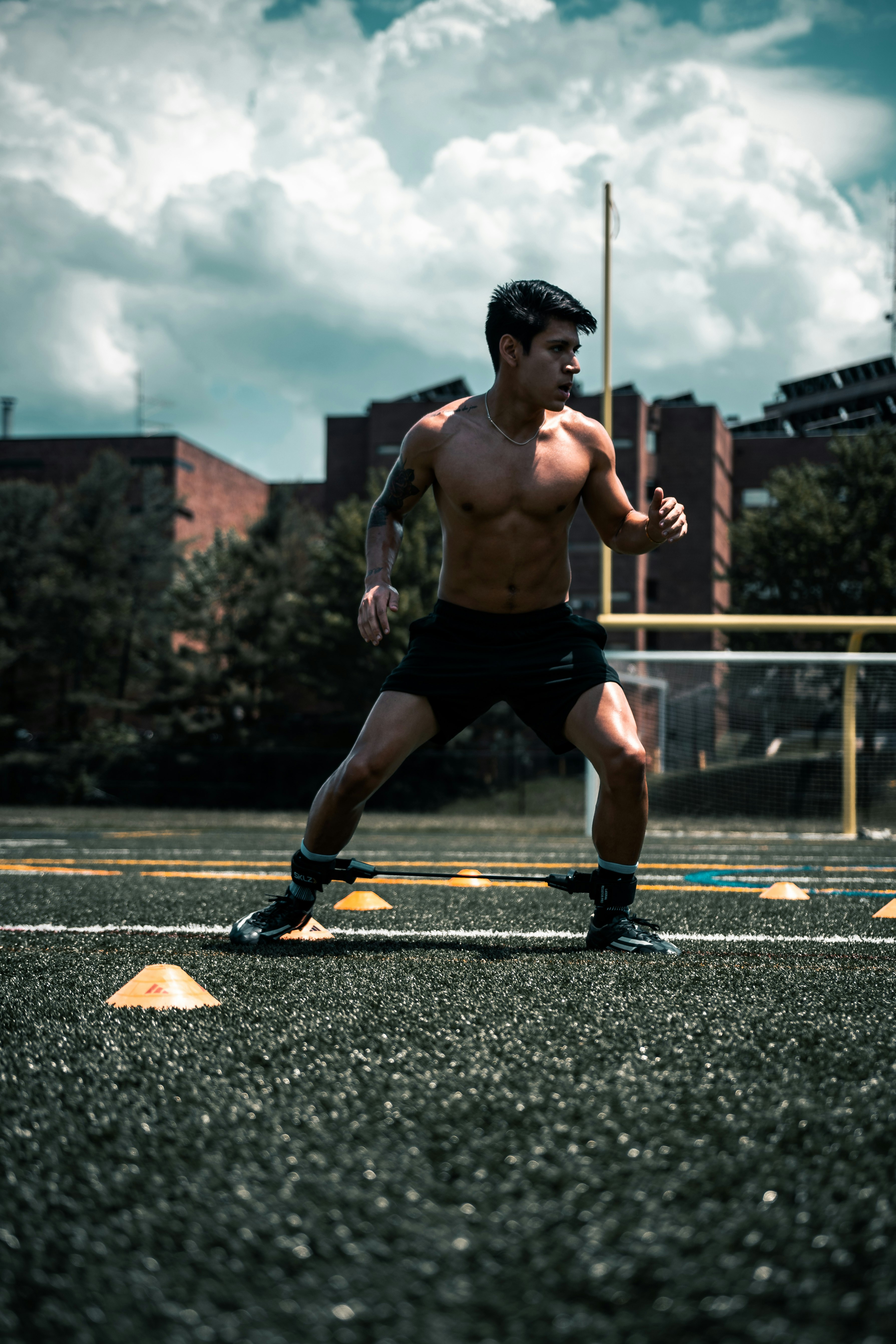 man in black shorts and black nike shoes running on road during daytime